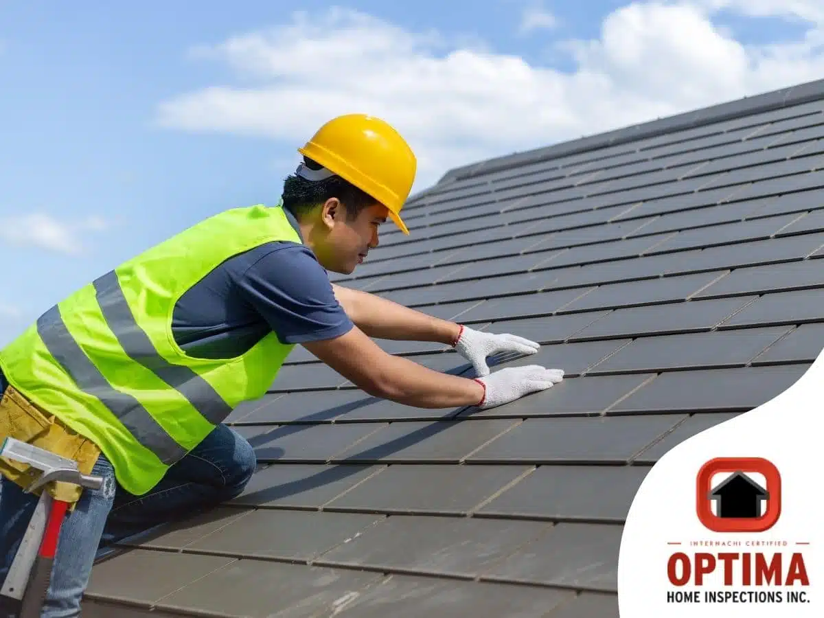 A home inspector inspecting shingles on a roof.